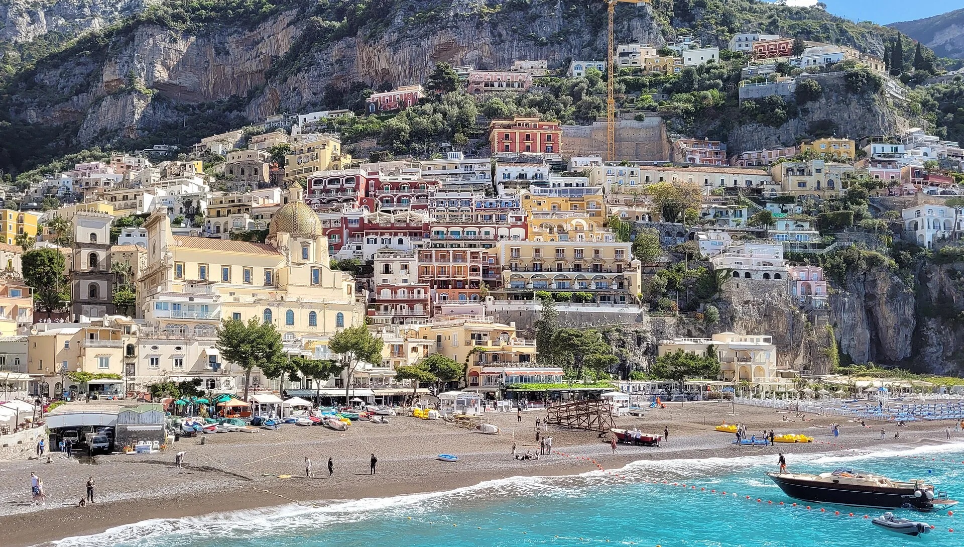 Vista di Positano dal mare, con le case colorate arrampicate sulla collina e la spiaggia sul golfo
